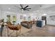 Open-concept living room with modern furnishings, hardwood floors, and a view of the kitchen and backyard at 1301 Paradise Ln, Winter Park, FL 32792