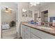 Bathroom with granite countertops, double sinks, and neutral cabinets at 141 Dommerich Dr, Maitland, FL 32751