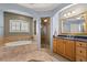 Well-appointed bathroom with a soaking tub, a glass-enclosed shower, and granite counters at 141 Dommerich Dr, Maitland, FL 32751