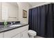 Bathroom with dark marble countertop, white vanity, and blue shower curtain at 141 Dommerich Dr, Maitland, FL 32751