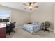 Cozy bedroom featuring a ceiling fan, a patterned quilt, and a dedicated desk workspace at 141 Dommerich Dr, Maitland, FL 32751