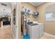 Functional laundry room with washer, dryer, storage shelving, and natural light at 141 Dommerich Dr, Maitland, FL 32751