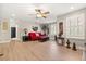Bright living room featuring a red sofa, wood floors, and modern ceiling fan at 141 Dommerich Dr, Maitland, FL 32751