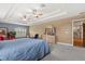 Spacious main bedroom with a tray ceiling, dual ceiling fans, and a bright window at 141 Dommerich Dr, Maitland, FL 32751