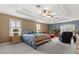 Spacious main bedroom with tray ceilings, dual ceiling fans, and a cozy sitting area at 141 Dommerich Dr, Maitland, FL 32751