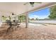 Covered patio with brick flooring, dining set, and a view of the pool with fountain at 141 Dommerich Dr, Maitland, FL 32751