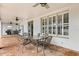 Covered patio with brick flooring, dining set, ceiling fans and exterior shutters at 141 Dommerich Dr, Maitland, FL 32751
