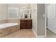 Bright Primary bathroom with a soaking tub, vanity with wood cabinets, and tile flooring for a relaxing spa-like experience at 14537 San Lorenzo Dr, Orlando, FL 32820