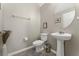 Clean powder room featuring a pedestal sink, round mirror, neutral walls, and tile floors for a modern, minimalist feel at 14537 San Lorenzo Dr, Orlando, FL 32820