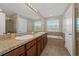 Bathroom featuring dual sinks, granite counters, and a soaking tub at 14537 San Lorenzo Dr, Orlando, FL 32820
