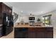 Modern kitchen featuring dark wood cabinets, granite countertops, and stainless steel appliances at 14537 San Lorenzo Dr, Orlando, FL 32820