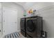 Modern laundry room features black front-loading washer and dryer with shelving and space-saving design at 14537 San Lorenzo Dr, Orlando, FL 32820
