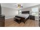Main bedroom with wood floors, a large bed, windows, and a ceiling fan at 14537 San Lorenzo Dr, Orlando, FL 32820
