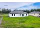 Well-maintained backyard featuring green grass and a white exterior of the home at 16734 Sw 18Th Avenue Rd, Ocala, FL 34473