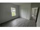 Unfurnished bedroom showcasing wood-look floors, closet, and a large window with a view at 16734 Sw 18Th Avenue Rd, Ocala, FL 34473