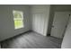 Simple bedroom featuring a large window, closet, neutral decor, and wood-look flooring at 16734 Sw 18Th Avenue Rd, Ocala, FL 34473
