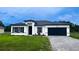 Charming single-story home featuring a dark garage door, modern architecture, and a well-maintained lawn at 16734 Sw 18Th Avenue Rd, Ocala, FL 34473