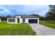 Inviting home showcasing a gray brick driveway, dark roof, manicured lawn and a modern facade at 16734 Sw 18Th Avenue Rd, Ocala, FL 34473