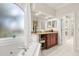 Inviting bathroom featuring a soaking tub, granite countertops, and decorative accents at 1855 Vista Royale Blvd, Orlando, FL 32835