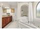 Bright bathroom showcasing a soaking tub, granite countertops, and a tiled floor at 1855 Vista Royale Blvd, Orlando, FL 32835