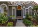 Inviting front entrance with arched door, decorative windows, and colorful landscaping at 1855 Vista Royale Blvd, Orlando, FL 32835