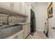 Laundry room featuring modern stacked washer and dryer, stainless steel sink, and custom cabinetry at 1855 Vista Royale Blvd, Orlando, FL 32835