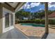 Tranquil backyard showcasing the refreshing pool with beautiful lush landscaping, viewed from the covered patio at 1855 Vista Royale Blvd, Orlando, FL 32835