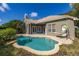 Inviting backyard featuring a sparkling pool, stone patio, and lush tropical landscaping at 1855 Vista Royale Blvd, Orlando, FL 32835
