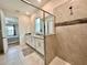 Spacious bathroom with a double vanity, large mirror, and a walk-in shower with tiled walls at 2034 Fleming Mist Pl, Kissimmee, FL 34747