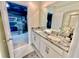 Bathroom vanity featuring double sinks and granite countertops; bedroom view in background at 2034 Fleming Mist Pl, Kissimmee, FL 34747