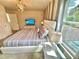 Bright bedroom featuring a large window, modern lighting, and a stylish, comfortable bed at 2034 Fleming Mist Pl, Kissimmee, FL 34747