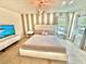 Inviting bedroom featuring a striped accent wall, modern lighting, and two bright windows at 2034 Fleming Mist Pl, Kissimmee, FL 34747