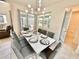 Bright dining area features modern chandelier, patio access, and a dining table set for eight at 2034 Fleming Mist Pl, Kissimmee, FL 34747