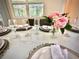 Close-up shot of a dining table elegantly set with wine glasses, plates and floral arrangement at 2034 Fleming Mist Pl, Kissimmee, FL 34747