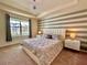 Luxurious main bedroom featuring tray ceiling, modern lighting, and large windows at 2034 Fleming Mist Pl, Kissimmee, FL 34747