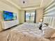 Bright main bedroom featuring an elegant bed, stylish decor, and a view of the neighborhood at 2034 Fleming Mist Pl, Kissimmee, FL 34747