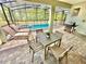 Covered and screened in patio with outdoor dining set and grill overlooking the pool at 2034 Fleming Mist Pl, Kissimmee, FL 34747