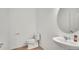 Modern half-bathroom features pedestal sink, a wall mirror, and neutral decor at 2203 Bluebird Pl, St Cloud, FL 34771