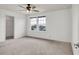 An empty bedroom showing neutral carpet, large windows, and a ceiling fan with overhead lighting at 2203 Bluebird Pl, St Cloud, FL 34771