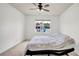 Carpeted bedroom with a ceiling fan and window providing natural light, creating a serene and comfortable space at 2203 Bluebird Pl, St Cloud, FL 34771