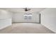 Spacious bonus room featuring neutral carpet, a ceiling fan, and bright natural light from a window at 2203 Bluebird Pl, St Cloud, FL 34771