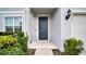 Close-up of the home's entrance, featuring a stylish blue front door and manicured landscaping at 2203 Bluebird Pl, St Cloud, FL 34771