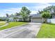 Single-story home with an attached garage and a long driveway, nestled in a neighborhood with mature trees and green lawns at 227 Morning Glory Dr, Lake Mary, FL 32746