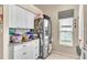 Kitchen with stainless steel refrigerator, white cabinets, and tile flooring at 227 Morning Glory Dr, Lake Mary, FL 32746
