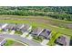 An aerial perspective shows a community's homes near green fields and wooded areas at 2294 Gold Dust Dr, Minneola, FL 34715