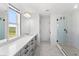 Modern bathroom with double sink vanity, glass shower, and stylish marble-like tile floors at 2294 Gold Dust Dr, Minneola, FL 34715