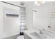 Clean, all-white bathroom with white tiled walls, modern vanity, and patterned shower curtain at 2294 Gold Dust Dr, Minneola, FL 34715