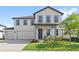 Charming two-story home with white siding, grey trim, landscaped yard, and a welcoming front porch at 2294 Gold Dust Dr, Minneola, FL 34715