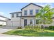 Charming two-story home with white siding, grey trim, landscaped yard, and a welcoming front porch at 2294 Gold Dust Dr, Minneola, FL 34715