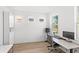 Bright home office with wood floors, white walls, built-in cabinets, and a modern desk setup at 2294 Gold Dust Dr, Minneola, FL 34715